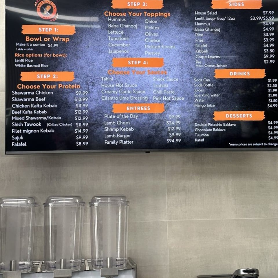 Shawarma Shack's menu board displays halal options for bowls, wraps, proteins, toppings, sauces, sides, drinks, entrees, and desserts.